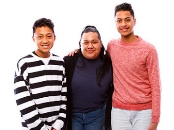 A family standing together: 2 young boys and a woman.