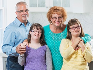 A family standing together, 2 parents and 2 daughters.