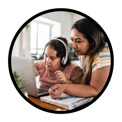 An adult looking at a laptop with their child.