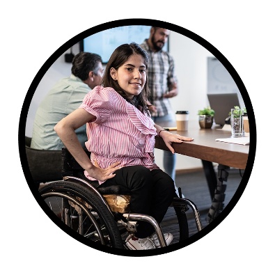 A person with disability at a table with a group of people talking.
