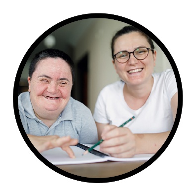 A person supporting a participant to write.