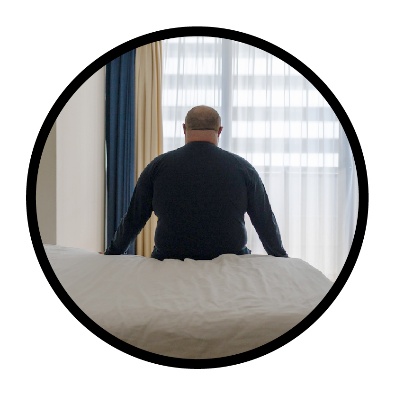 A person sitting on a bed alone.