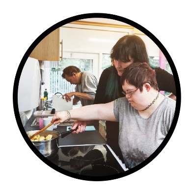 A person supporting someone to cook.
