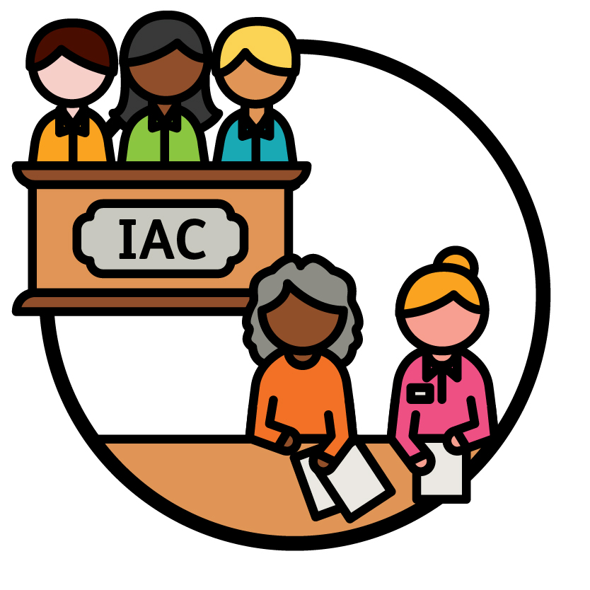A group of 3 people sitting behind a bench that says 'IAC' on the front, and 2 Independent Advisors.