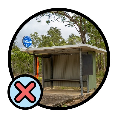 An outdoor bus stop with a cross icon next to it. 