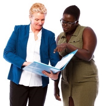 Two women looking at a document. 