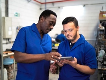 Two people looking at an iPad together at work.