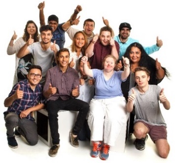 A large group of people smiling with 2 thumbs up.