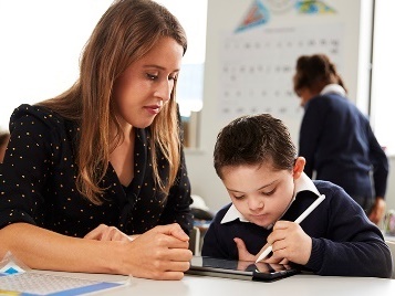 A teacher helping a young child. 