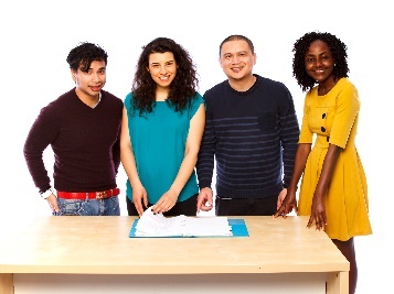 4 smiling people around a table with documents on it.