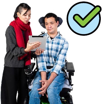 A person supporting someone with disability to use a digital tablet.