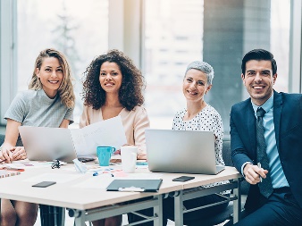 A group of professionals sitting at a table smiling.