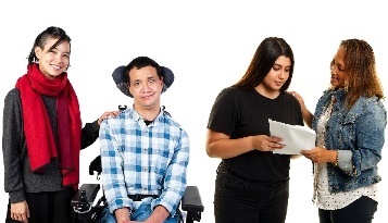 A person supporting someone in a wheelchair, and another person supporting someone to read a document.