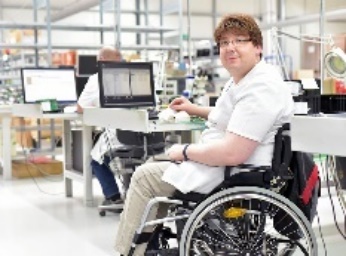 A photo of a person in a wheelchair working in an office. 