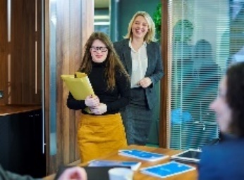 A photo of three people in an office. 