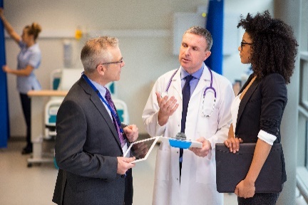 A health professional having a conversation with 2 other service providers.