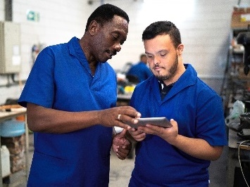 Two people looking at an iPad together at work.