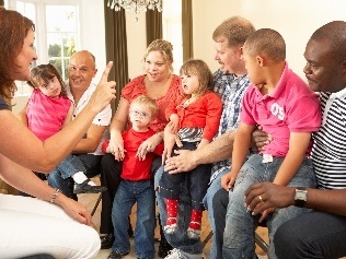 A group of families listening to someone speak.