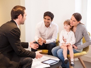 2 parents and a child having a conversation a government worker.