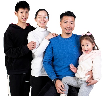 A family of 2 parents and 2 children. They are all smiling.