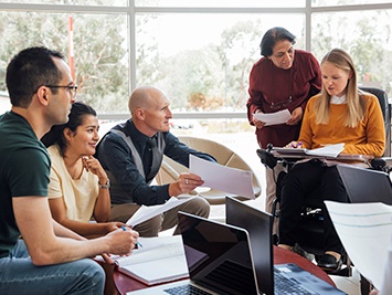 A group of people working together on a document in a meeting.