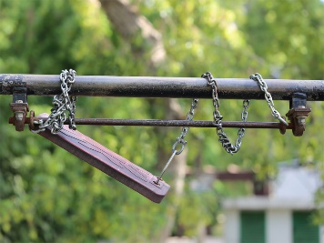 Damaged playground swing.