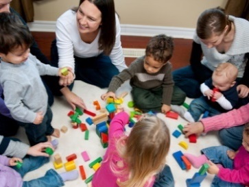 A group of parents and their young children learning by playing together.