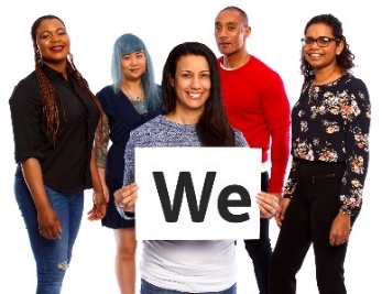 A group of people. There is a person in front holding a card that reads 'We'.