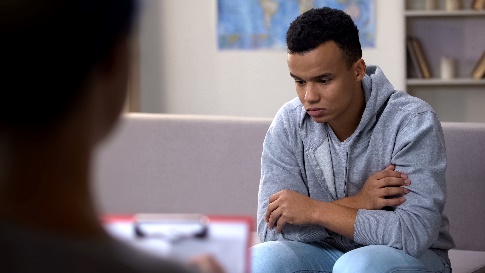 A young person with their arms folded across their chest. They look upset.