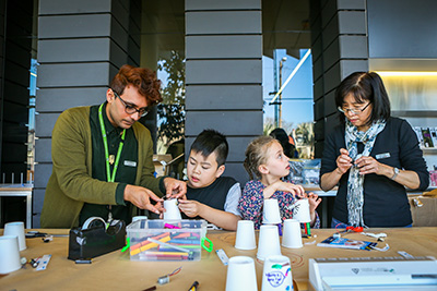 2 children and 2 volunteers in an art class.