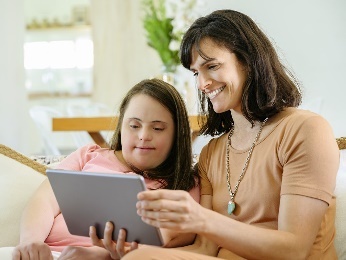A person supporting a participant to use a digital tablet.