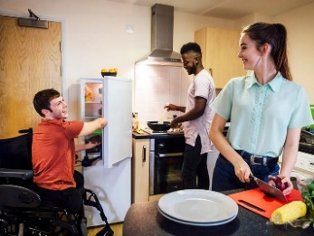 A group of roommates preparing a meal together. 