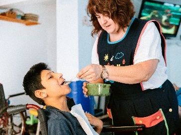 An SDA provider supporting a participant at mealtime.