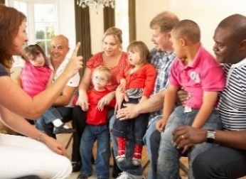 A group of children and their parents in a meeting.