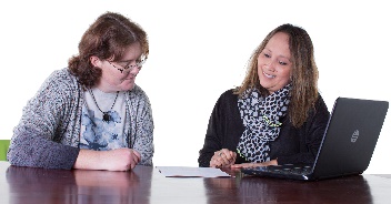 A person with disability being supported to read a document.